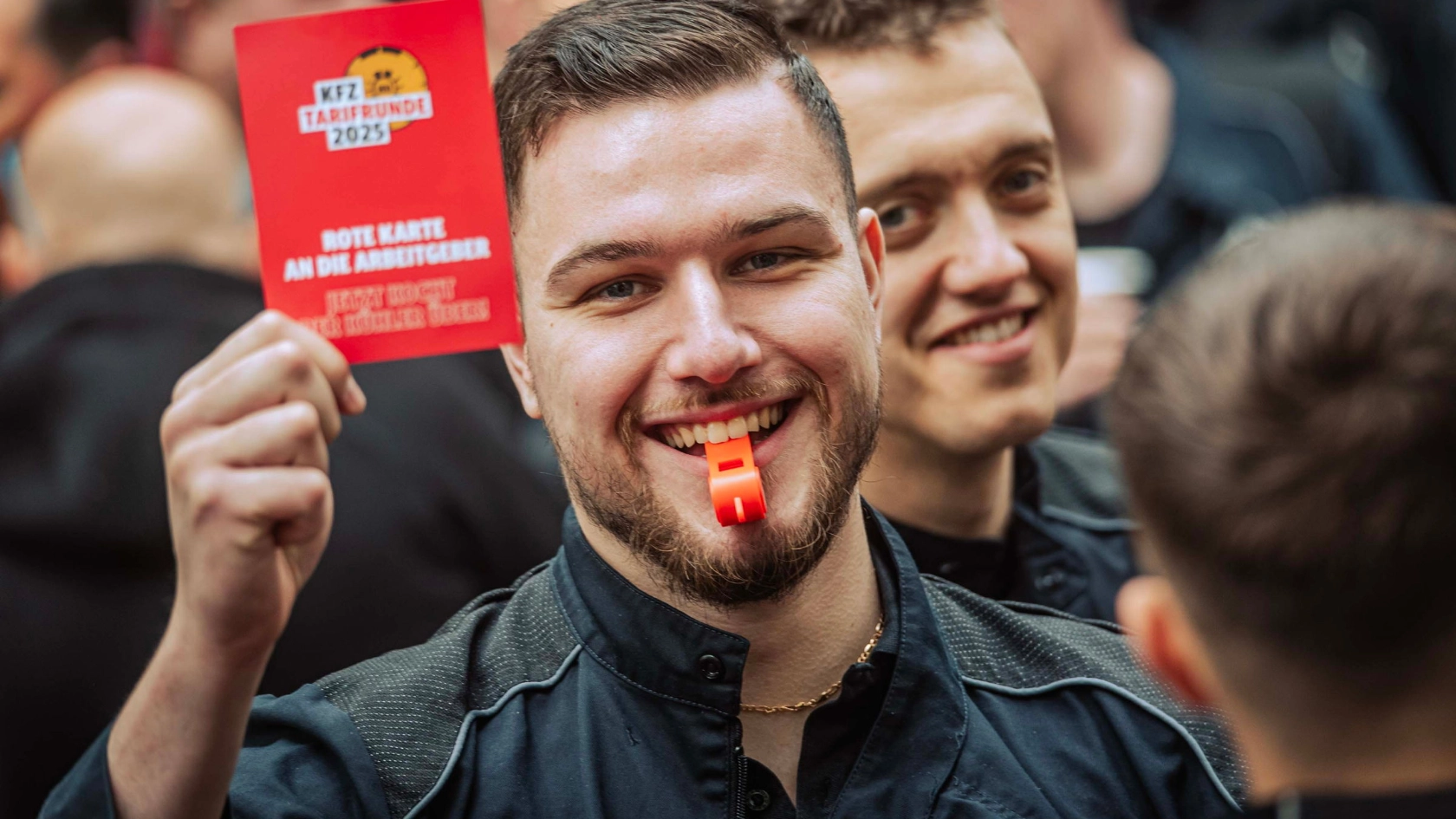 Beschäftigter zeigt Arbeitgebern während der Kfz-Tarifrunde 2025 die symbolische Rote Karte.